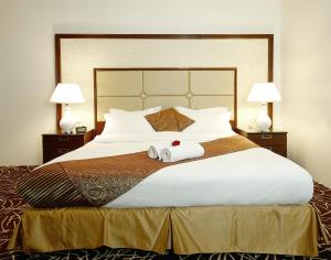 Rest Night Hotel Apartment- AlHamra في الرياض: غرفة نوم بسرير كبير عليها منشفتين