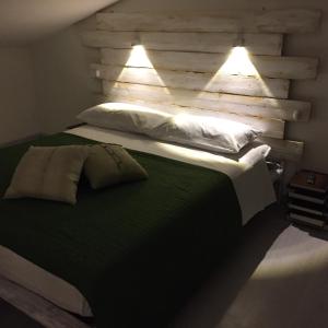 a bedroom with a large bed with two lights on it at Mansarda 13 in Salerno