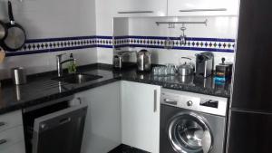 kuchnia z pralką i zlewem w obiekcie Casita Andaluza w mieście San Luis de Sabinillas