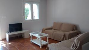 salon z kanapą, krzesłem i telewizorem w obiekcie Casita Andaluza w mieście San Luis de Sabinillas
