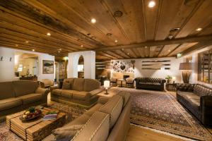 a living room with leather furniture and a wooden ceiling at Hotel Hocheder in Seefeld in Tirol