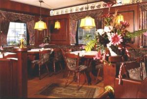 a dining room with a table and chairs and flowers at Landgasthof Deutsches Haus in Ulmbach