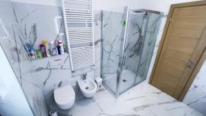 a bathroom with a shower and a toilet and a sink at Appartamento Nerio in Muggia +22 photos