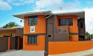 a orange building with an orange door and windows at Culture Crossroads Inn in Port-of-Spain