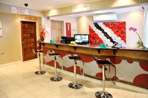 a bar in a hotel with stools at a counter at Culture Crossroads Inn in Port-of-Spain