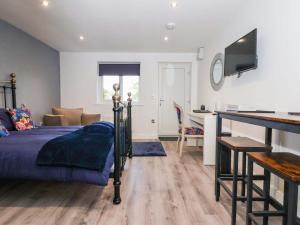 a bedroom with a bed and a desk at Chalet 3 in Ganton +9 photos