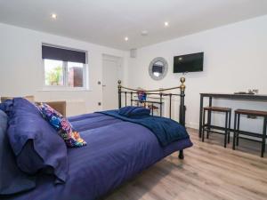 a bedroom with a bed with purple sheets and a desk at Chalet 3 in Ganton