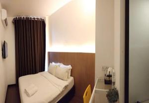 a small room with a small bed and a window at Point Stay BDC Airport in Kuching