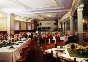 a banquet hall with tables and chairs with white tablecloths at Landgasthof Deutsches Haus in Ulmbach