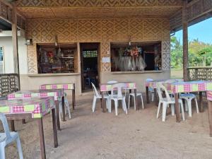 a group of tables and chairs in front of a restaurant at Dapearl Cottage in Baclayon