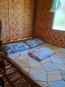 a large bed in a room with a window at Dapearl Cottage in Baclayon