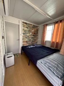 a bedroom with a bed and a brick wall at RT House Resort in Ban Phawon