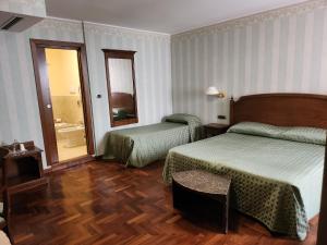 a hotel room with two beds and a mirror at Pretoria Collection in Potenza