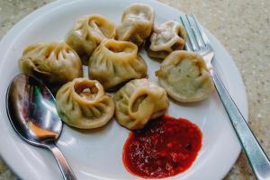 a plate of dumplings with sauce on a table at Super OYO Hotel O Sankat Mochan Gandhi Nagar in Kakarmatha +41 photos