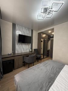 a bedroom with a bed and a desk and a television at Gyumri Moderna in Gyumri