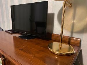a television on a wooden table with a lamp at Pretoria Collection in Potenza