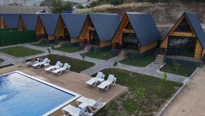 an aerial view of a house with a pool and lounge chairs at Evergreen Lodge in Çakırlar