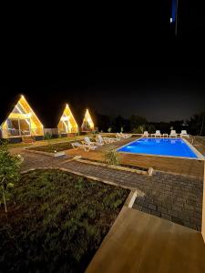 a resort with a swimming pool at night at Evergreen Lodge in Çakırlar