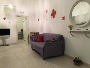 salon z kanapą i lustrem w obiekcie Casa Comasia w mieście Martina Franca