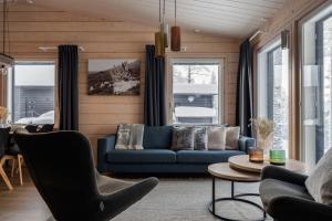 a living room with a blue couch and a table at Louhi A in Äkäslompolo