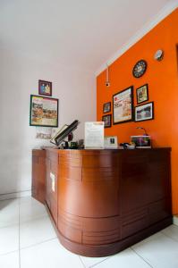 a cashier counter with an orange wall at Fora Guest House Taman Lingkar in Bandung