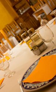 Ateca的住宿－Hostal El Bodegon，桌子上带橙色餐巾的盘子