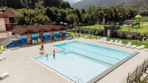 a large swimming pool with two people playing in it at Sarca Lodge Val Rendena in Dare