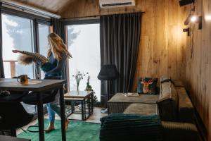 a woman standing in a living room with a table at Domek Jak z Obrazka in Sierpnica