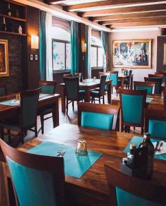 a restaurant with wooden tables and chairs with blue napkins at Locanda Munerato in Padova +12 photos