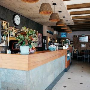 a restaurant with a bar with a clock on the wall at Locanda Munerato in Padova