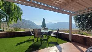 a table and chairs on a patio with a view at Uitkyk Guest House in Fouriesburg