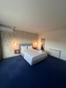 a bedroom with a large white bed and blue carpet at White Guest in Fátima