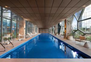 a large swimming pool with blue water in a building at Spencer on Rock in Melbourne