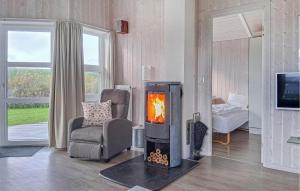 a living room with a fireplace and a chair at Friedrichskoog-Strandpark 1 in Friedrichskoog