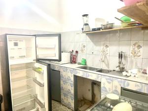 a kitchen with a sink and a refrigerator at Guest House HEBERTOGO in Lomé