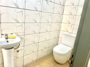 a bathroom with a toilet and a sink at Guest House HEBERTOGO in Lomé