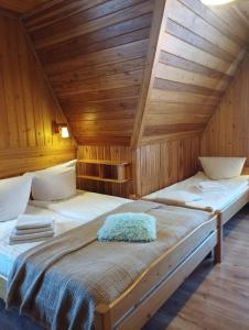 a bedroom with two beds in a wooden cabin at DW Łomnica in Białka Tatrzańska