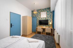 a room with a bed and a desk and a tv at WOW City Hostel in Budapest