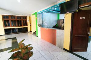 a room with a kitchen with a plant in the middle at Hotel Pattimura powered by Cocotel in Stasiun Tawang
