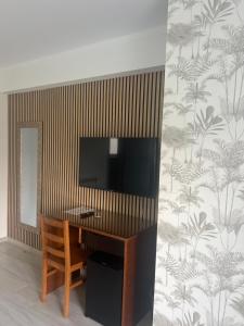 a room with a desk with a television on a wall at White Guest in Fátima