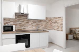 a kitchen with white cabinets and a sink and a microwave at MontBliss in Saint Vincent +13 photos