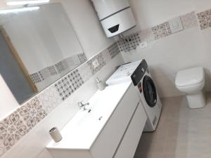 a white bathroom with a sink and a toilet at MontBliss in Saint Vincent