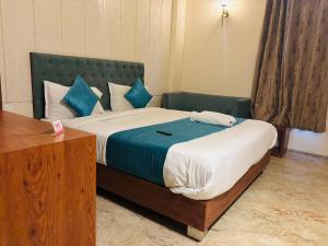 a bedroom with a large bed with blue pillows at Hotelgirdharinn in Indore