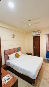 a bedroom with a large white bed and a table at Hotelgirdharinn in Indore
