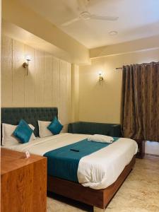 a bedroom with a large bed with blue pillows at Hotelgirdharinn in Indore