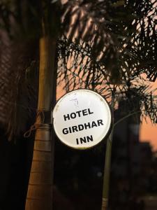 a sign on a pole next to a tree at Hotelgirdharinn in Indore