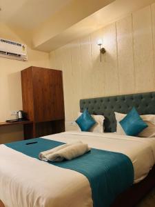 a hotel room with two beds with blue pillows at Hotelgirdharinn in Indore