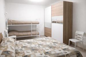 a bedroom with a bunk bed and a chair at MontBliss in Saint Vincent