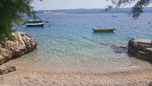 two boats sitting in the water on a beach at Apartments Drago Kovačić in Omiš