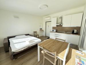 a bedroom with a bed and a table and a kitchen at BedE-Bike Apartments in Casazza